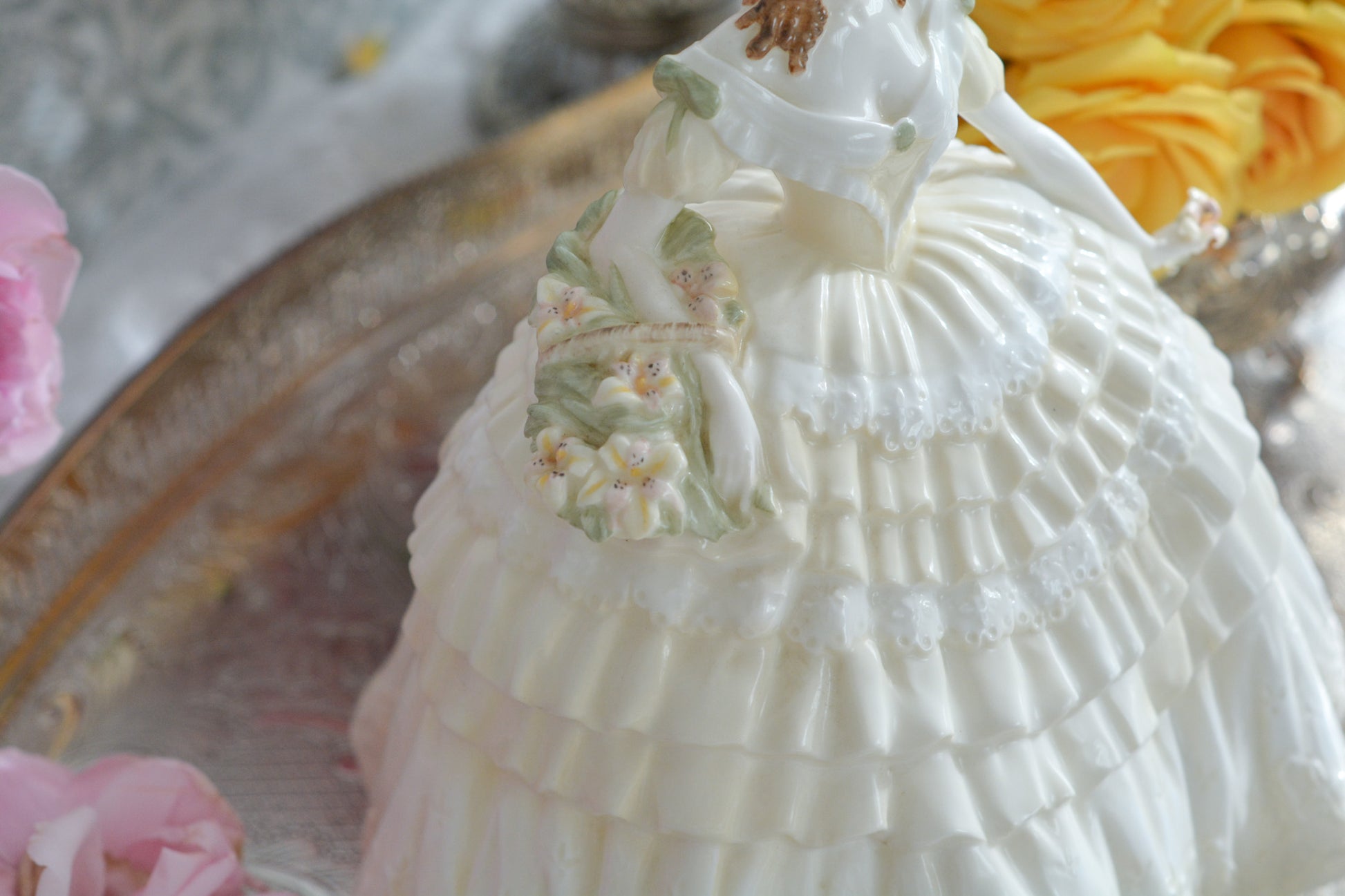 コールポートの人気フィギュリン、「The Four Flowers Collection」。名前の通り、「リリー、ローズ、カーネション、アイリス」の4つのお花がモチーフのフィギュリンシリーズです。 その中でも、リリーはアイリスと並び入手困難なお品です。  バスケットいっぱいのリリーと左手には一輪のリリーの花。ドレスはホワイトに淡いイエローのフリルとグリーンのリボンがあしらわれています。 柔らかな表情がとても可愛らしいレディのフィギュリンです。