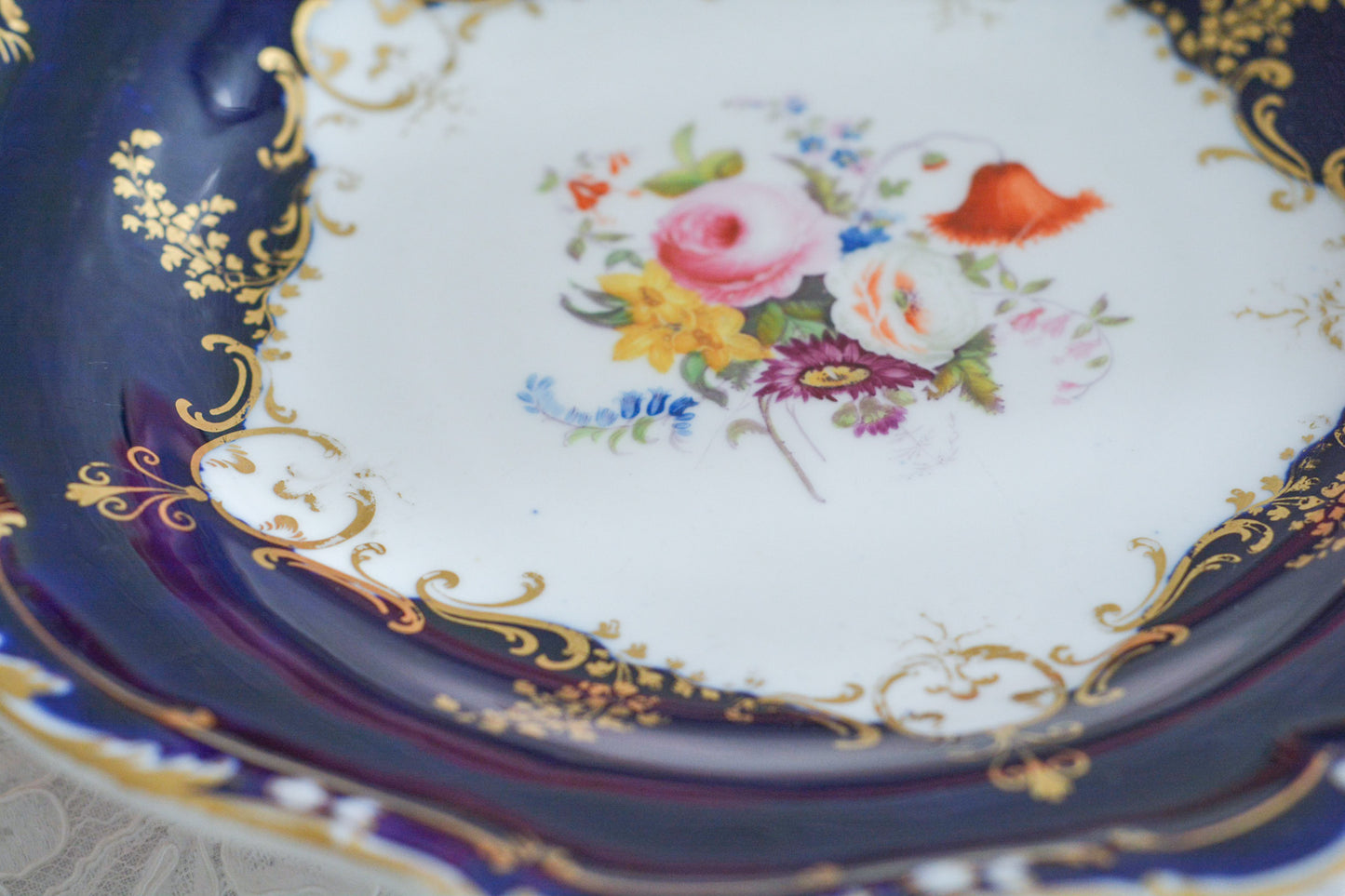 コバルトブルーカラーの美しいミントンのタッツァです。タッツァとはコンポートのような脚付きのプレートです。フルーツやお菓子を盛り付けるのにとても重宝するお品。美しいコバルトブルーカラーにハンドペイントのブーケがとても美しいです。あなたの大切なティータイムに是非お使いください