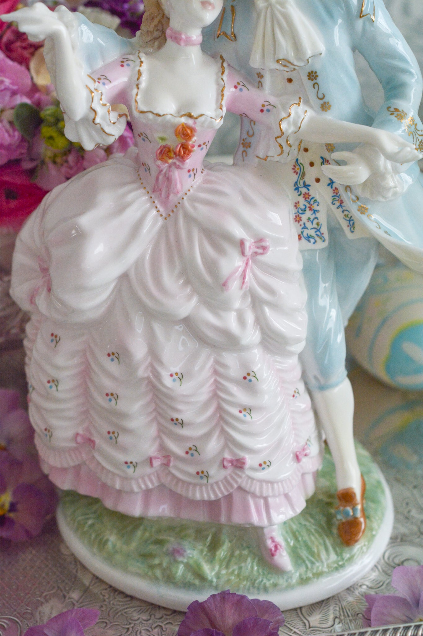 ロイヤルウースターの「AGE  OF CORTSHIP」シリーズの「The Flirtation」というフィギュリンです。「The Flirtation」「The Tryst」「The Betrothal」「The Proposal」があり、シリーズ名の通り、男女ペアのフィギュリンで構成されています。 寄り添ってダンスしているようにも見えます。 そしてパステルカラーの衣装の雰囲気やお顔の表情も柔らかく、初々しい様子も伝わってきます。2500体しか製造されていない大変貴重なフィギュリンです。