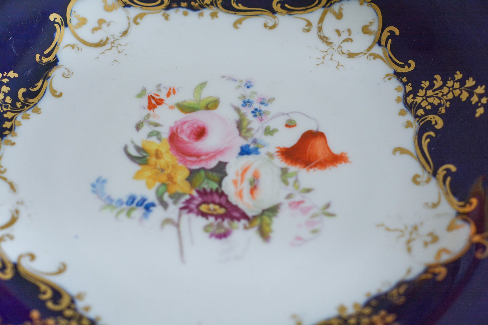 コバルトブルーカラーの美しいミントンのタッツァです。タッツァとはコンポートのような脚付きのプレートです。フルーツやお菓子を盛り付けるのにとても重宝するお品。美しいコバルトブルーカラーにハンドペイントのブーケがとても美しいです。あなたの大切なティータイムに是非お使いください