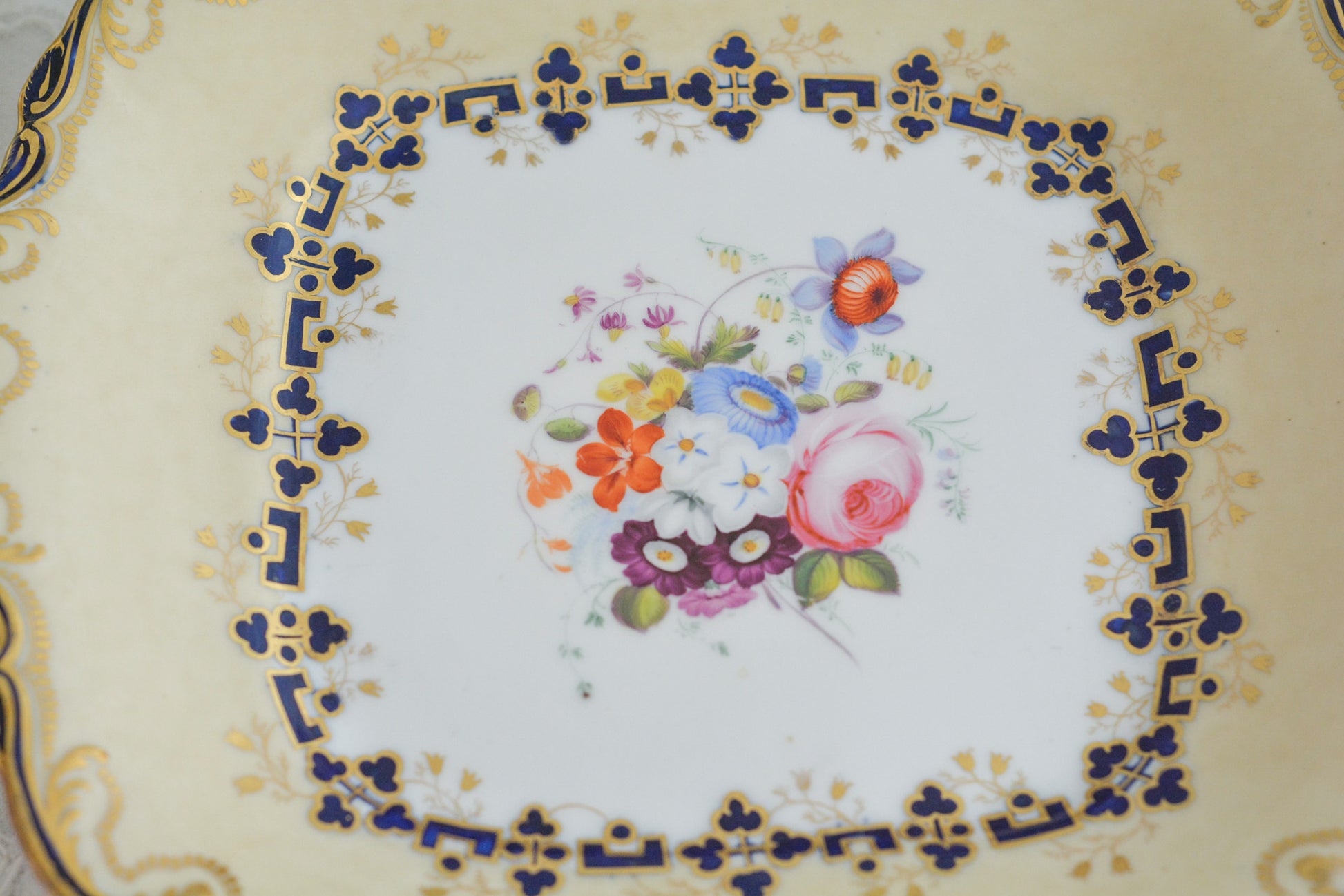 コールポートのアデレードシェイプのB&Bプレートです。ロココリバイバルの優雅なデザインが美しいです。ハンドペイントで描かれたブーケも大きく存在感もあり、ブーケを囲むコバルトブルーの模様もとっても可愛らしく、ブーケを引き立てています。B&Bとはブレッド&バターのことで、パンをもりつけたり、焼き菓子やフルーツなど様々な用途にお使いいただけます。テーブルがパッと華やかになるプレートです。