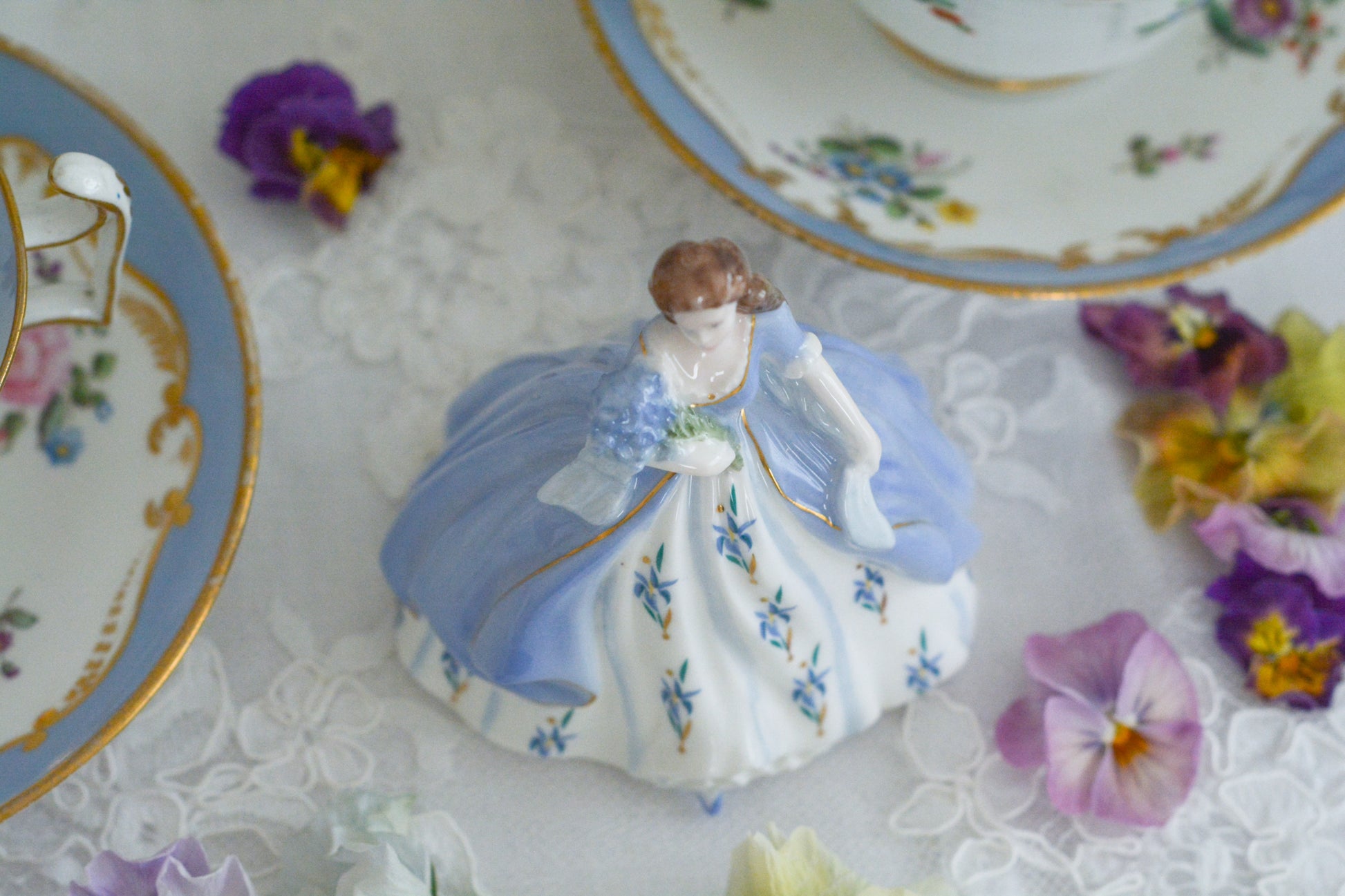コールポートの小さなフィギュリン「IRIS」。アイリスのブーケを抱えてドレスにもアイリスのお花があしらわれています。優しげな表情も美しい。ミニサイズですが存在感があります。ティータイムにも使いやすいサイズ感も嬉しいですね。このお花のシリーズの小さなフィギュリンは何種類かあり、ついつい集めたくなってしまいます。