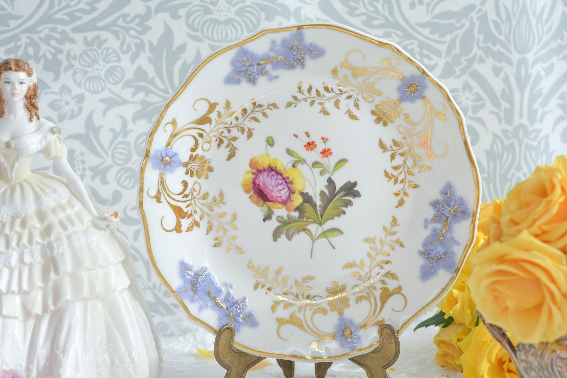 H&Rダニエルは1822年から1846年までという短い期間しか製造していないのですが、とても素晴らしい磁器を作っていたメーカです。 数がとても少なく、なかなか見つけることが難しいのですが「出会えたらいいな」と日々探していてこのプレートに巡り会えました!中央に描かれたお花は繊細なタッチで描かれています。縁の立体的な葡萄とお花の装飾はパープルブルーと金彩で彩られています。 この美しいプレートでティータイムをお楽しみいただけたら嬉しいです。