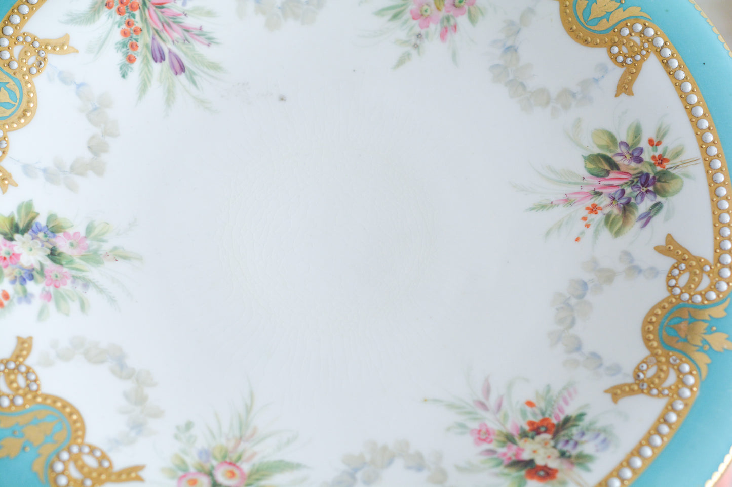 英国アンティーク、ミントンのターコイズブルーにエナメルのジュールが美しいコンポート。脚の部分の作りがミントンらしい繊細で優美な作品です。ハンドペイントで描かれた花々も生き生きとして特別なコンポートです。